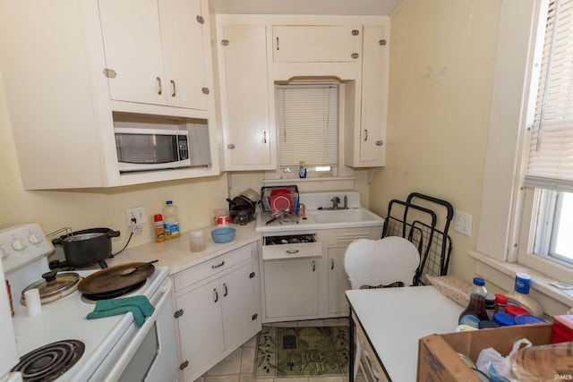 kitchen with white electric stove, white cabinetry, and light tile patterned flooring