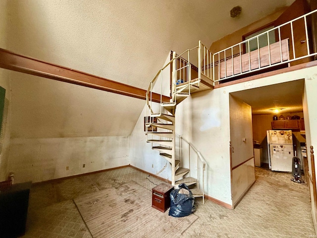 staircase with lofted ceiling, a textured ceiling, and carpet