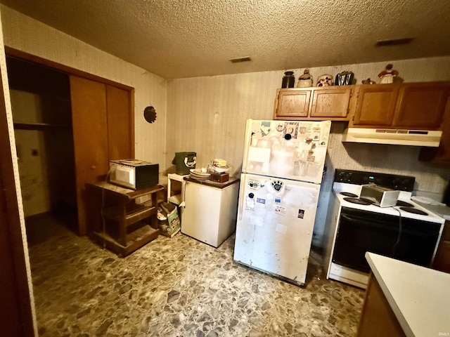 1839 S Meridian Rd, Mitchell, IN 47446 - kitchen featuring under cabinet range hood, white appliances, a textured ceiling, stone finish flooring, and brown cabinetry