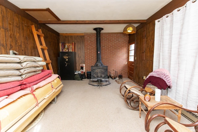 living room featuring wood walls, beam ceiling, carpet flooring, and a wood stove