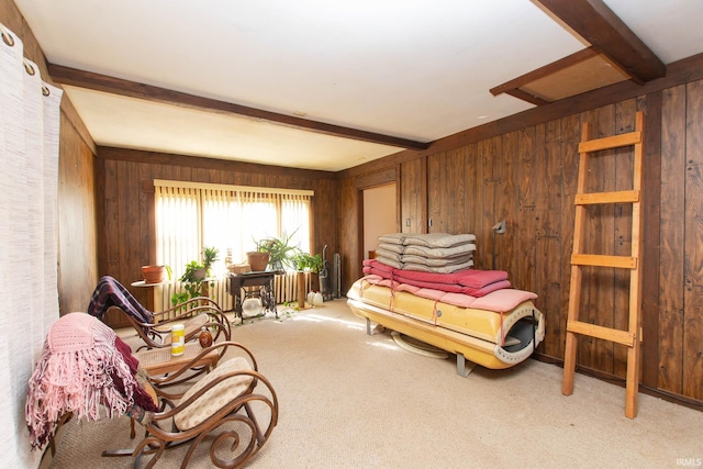 bedroom with wood walls, beam ceiling, and carpet flooring