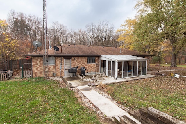 rear view of property with a patio, a sunroom, and a yard