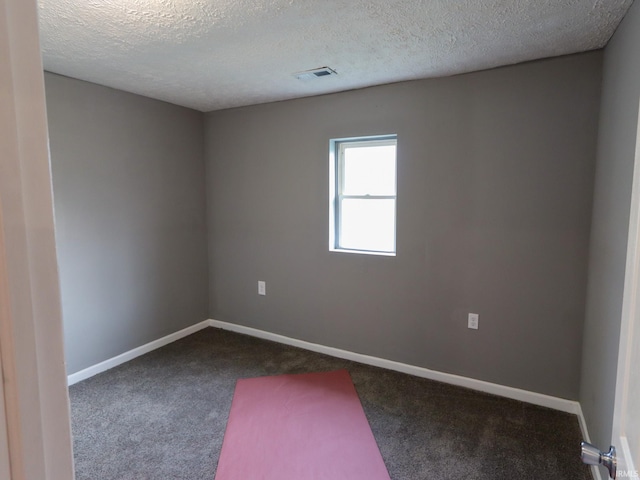 carpeted spare room with a textured ceiling