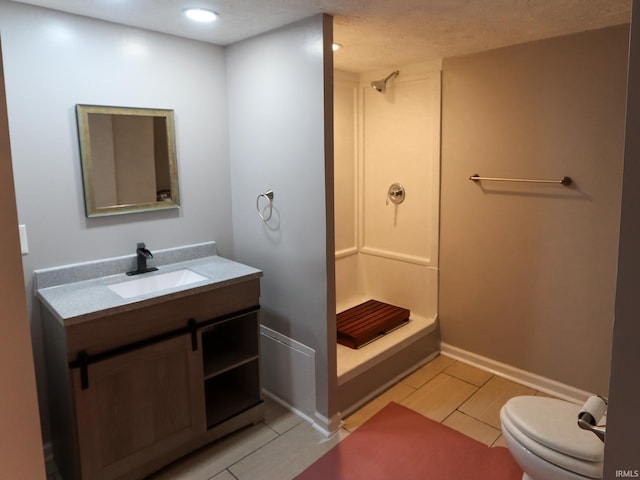 bathroom featuring vanity, a textured ceiling, toilet, and a shower