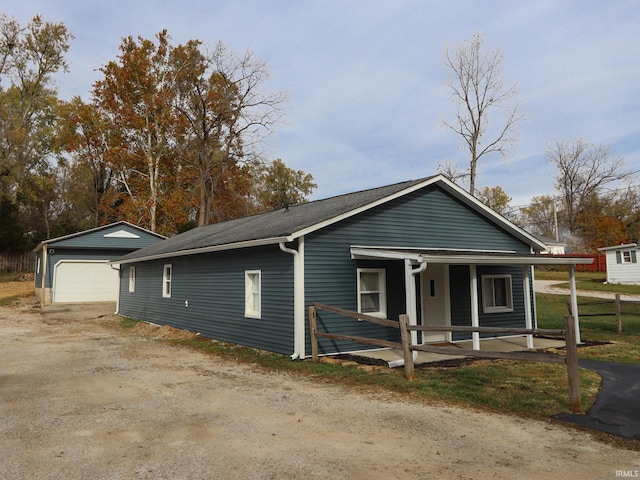 view of front of home with an outbuilding, a garage, and a porch