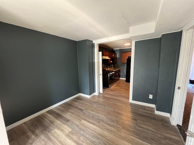 unfurnished room featuring wood-type flooring and sink