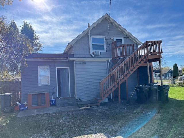 rear view of house with a lawn and a wooden deck