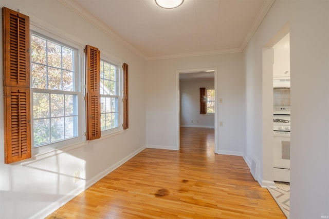 empty room with light wood-type flooring and crown molding