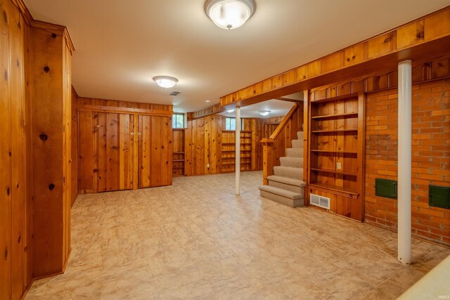 basement with wood walls and brick wall