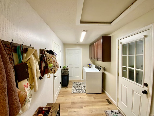 washroom featuring cabinets, light hardwood / wood-style floors, and washing machine and clothes dryer