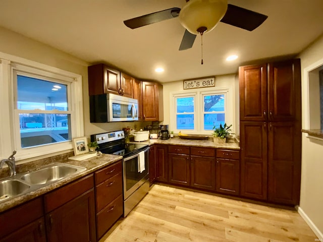 kitchen with stainless steel appliances, light hardwood / wood-style floors, sink, and ceiling fan