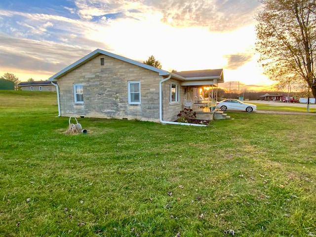 property exterior at dusk with a yard