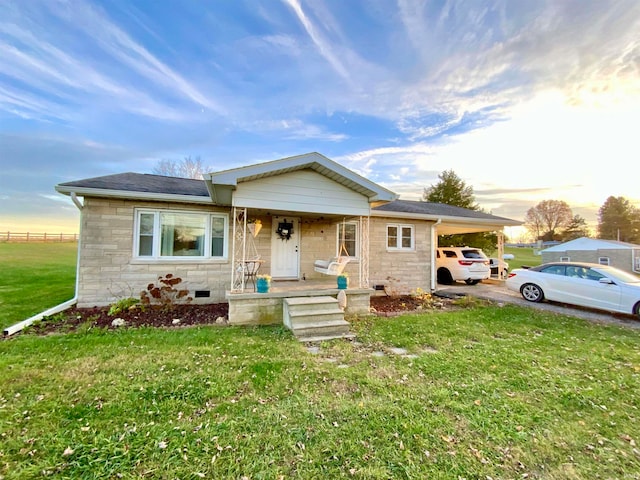 view of front of house with a porch, a yard, and a carport