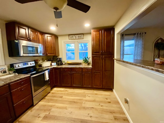 kitchen featuring a wealth of natural light, stainless steel appliances, ceiling fan, and light hardwood / wood-style flooring