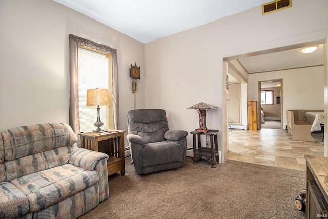 sitting room featuring a baseboard heating unit, carpet flooring, and plenty of natural light