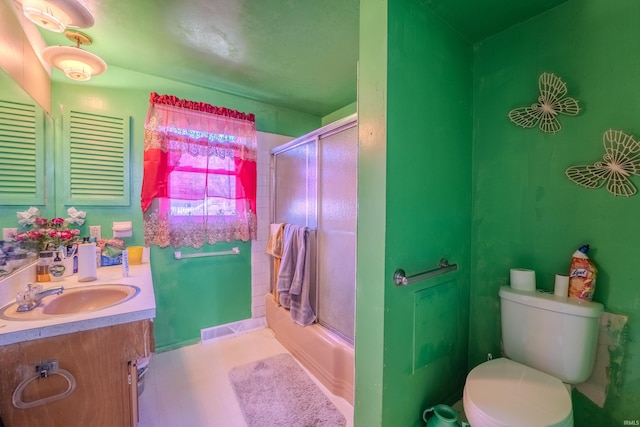 full bathroom featuring shower / bath combination with glass door, tile patterned flooring, toilet, and vanity