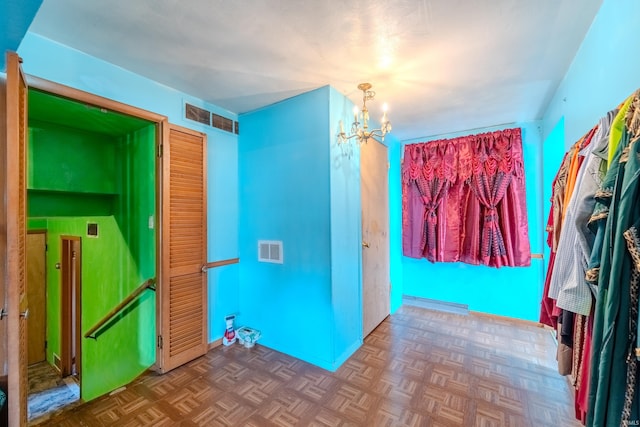 interior space featuring parquet flooring and an inviting chandelier