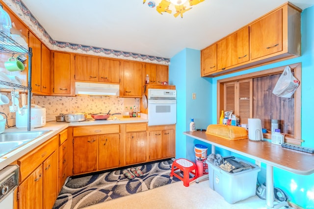 kitchen with white appliances, sink, and carpet