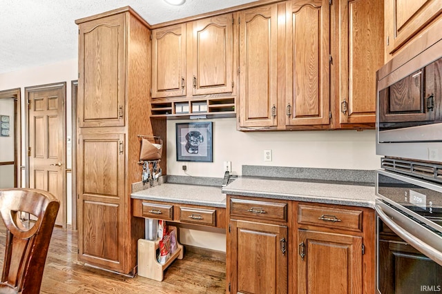 kitchen with light hardwood / wood-style floors and a textured ceiling