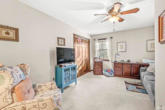 carpeted living room with ceiling fan