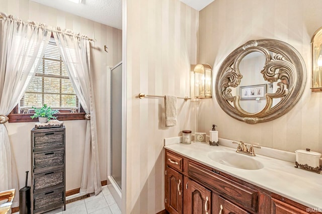 bathroom with vanity, a shower with shower door, a textured ceiling, and tile patterned floors