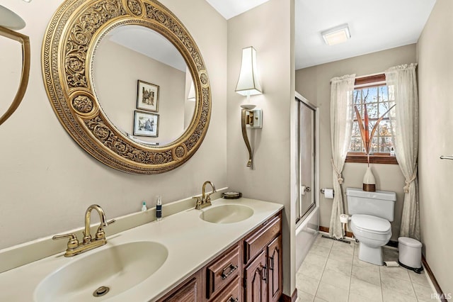 full bathroom featuring toilet, vanity, bath / shower combo with glass door, and tile patterned flooring