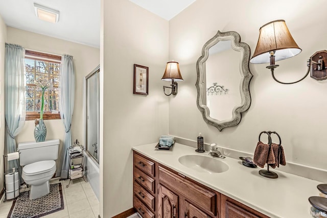 full bathroom featuring vanity, bath / shower combo with glass door, tile patterned floors, and toilet