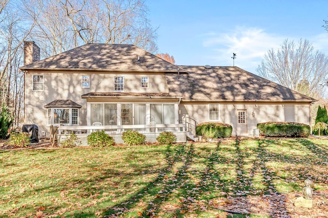 back of house with a lawn and a sunroom