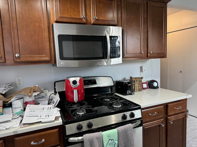 kitchen with light stone countertops and appliances with stainless steel finishes