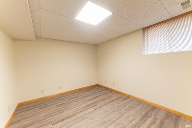 spare room featuring a paneled ceiling and hardwood / wood-style floors