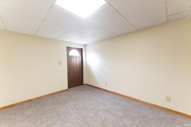 empty room with carpet flooring and a drop ceiling