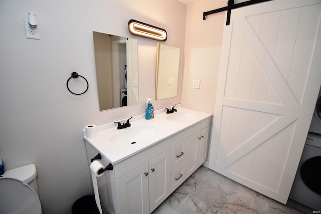 bathroom featuring vanity, stacked washer / dryer, and toilet