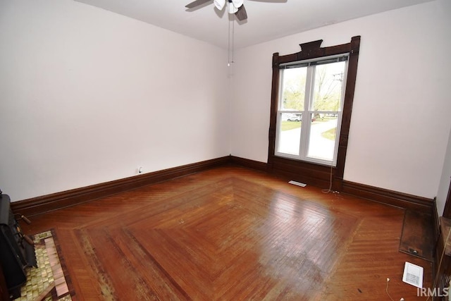 unfurnished room featuring ceiling fan and parquet floors