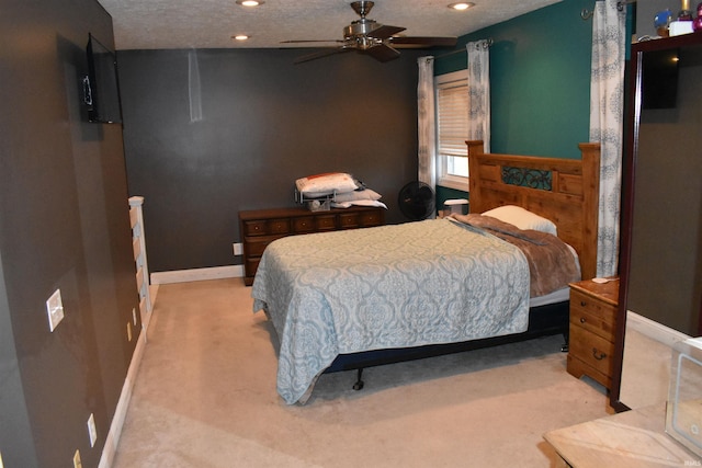 bedroom featuring light colored carpet, a textured ceiling, and ceiling fan