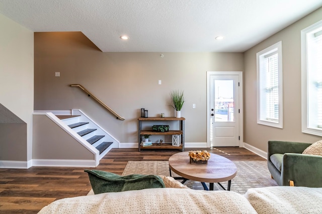 living room with a textured ceiling and dark hardwood / wood-style floors