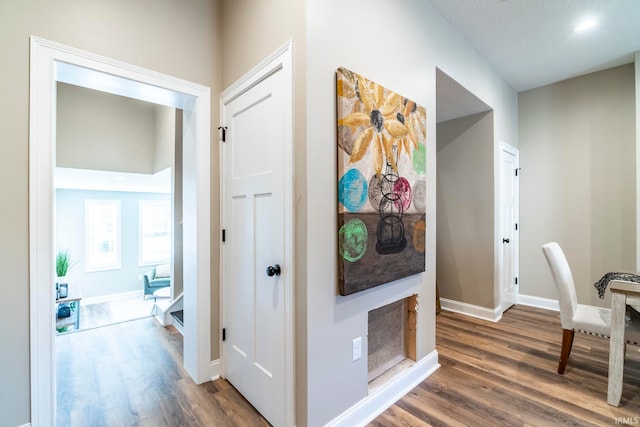 hall with a textured ceiling and dark hardwood / wood-style floors