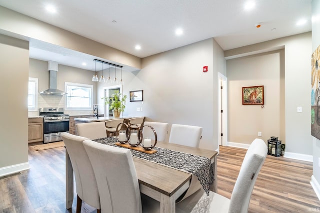 dining area with light hardwood / wood-style floors and sink