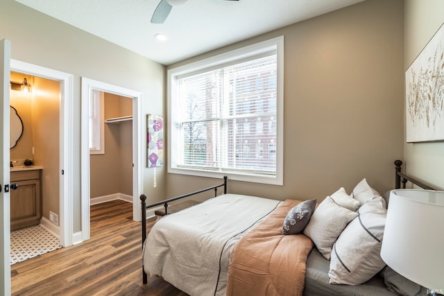 bedroom with hardwood / wood-style flooring, ensuite bath, ceiling fan, a spacious closet, and a closet