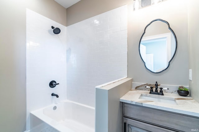 bathroom featuring tiled shower / bath and vanity