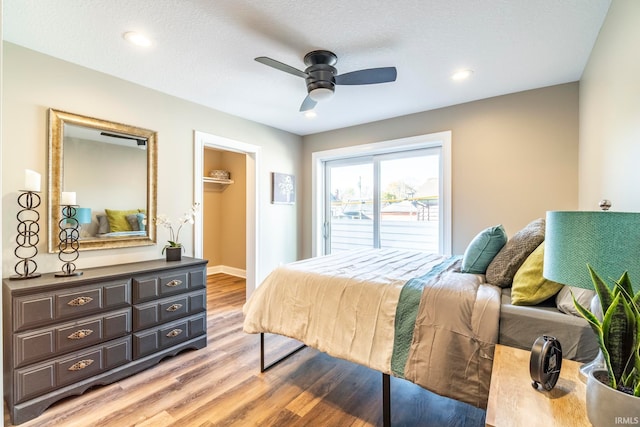 bedroom featuring a textured ceiling, ceiling fan, and light hardwood / wood-style flooring