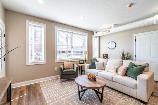 living room featuring wood-type flooring and a textured ceiling