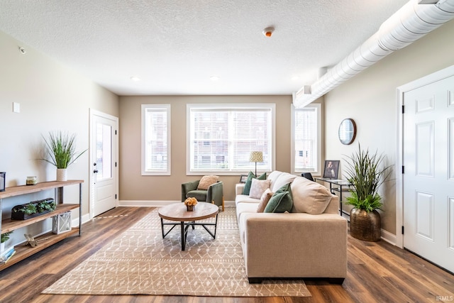 living room featuring dark hardwood / wood-style floors and a textured ceiling