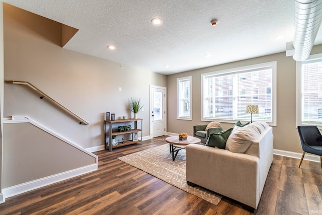 living room featuring dark wood-type flooring and a textured ceiling