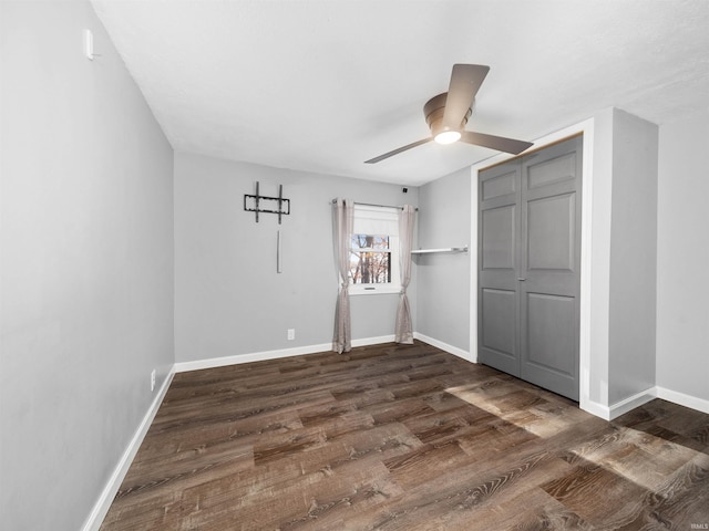 unfurnished bedroom with dark wood-type flooring, a closet, and ceiling fan