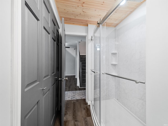 bathroom with a shower with door, hardwood / wood-style flooring, and wood ceiling