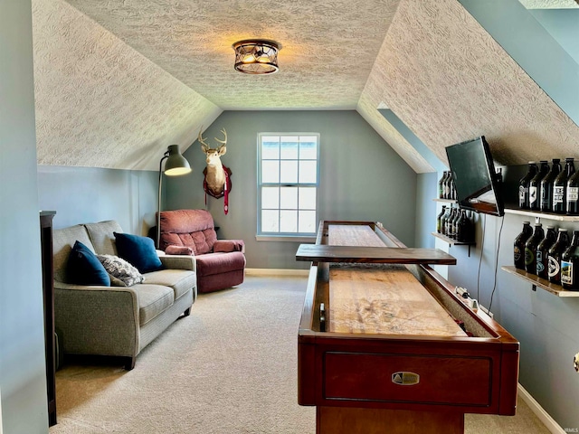 recreation room with light colored carpet, a textured ceiling, and vaulted ceiling