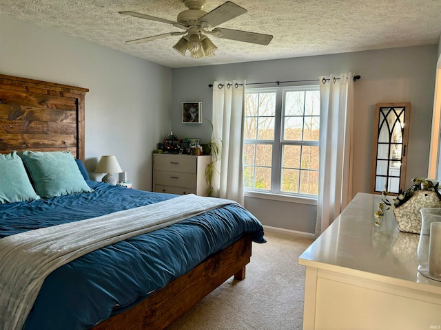 carpeted bedroom featuring a textured ceiling and ceiling fan