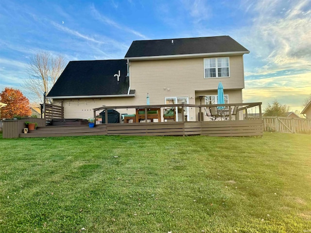 rear view of house featuring a lawn and a wooden deck