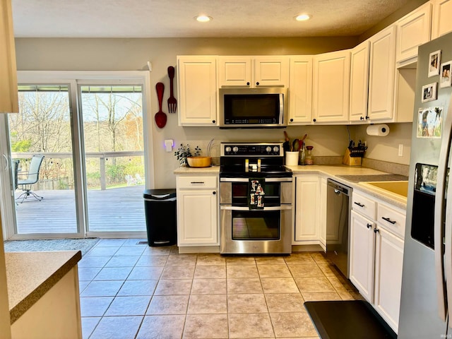 kitchen featuring white cabinetry, appliances with stainless steel finishes, and light tile patterned floors