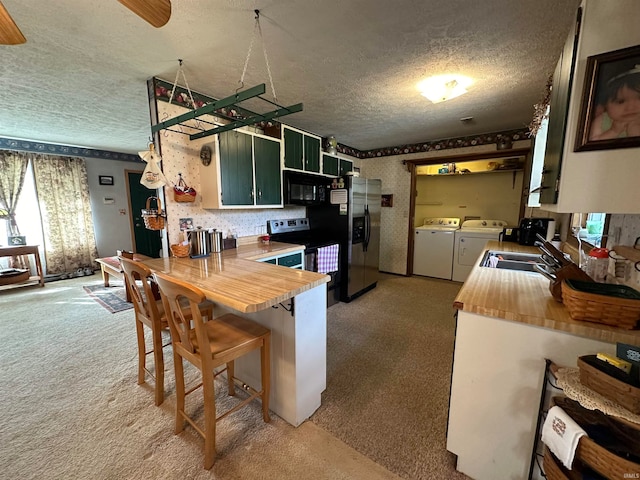 kitchen with stainless steel refrigerator with ice dispenser, light colored carpet, green cabinetry, and washing machine and clothes dryer